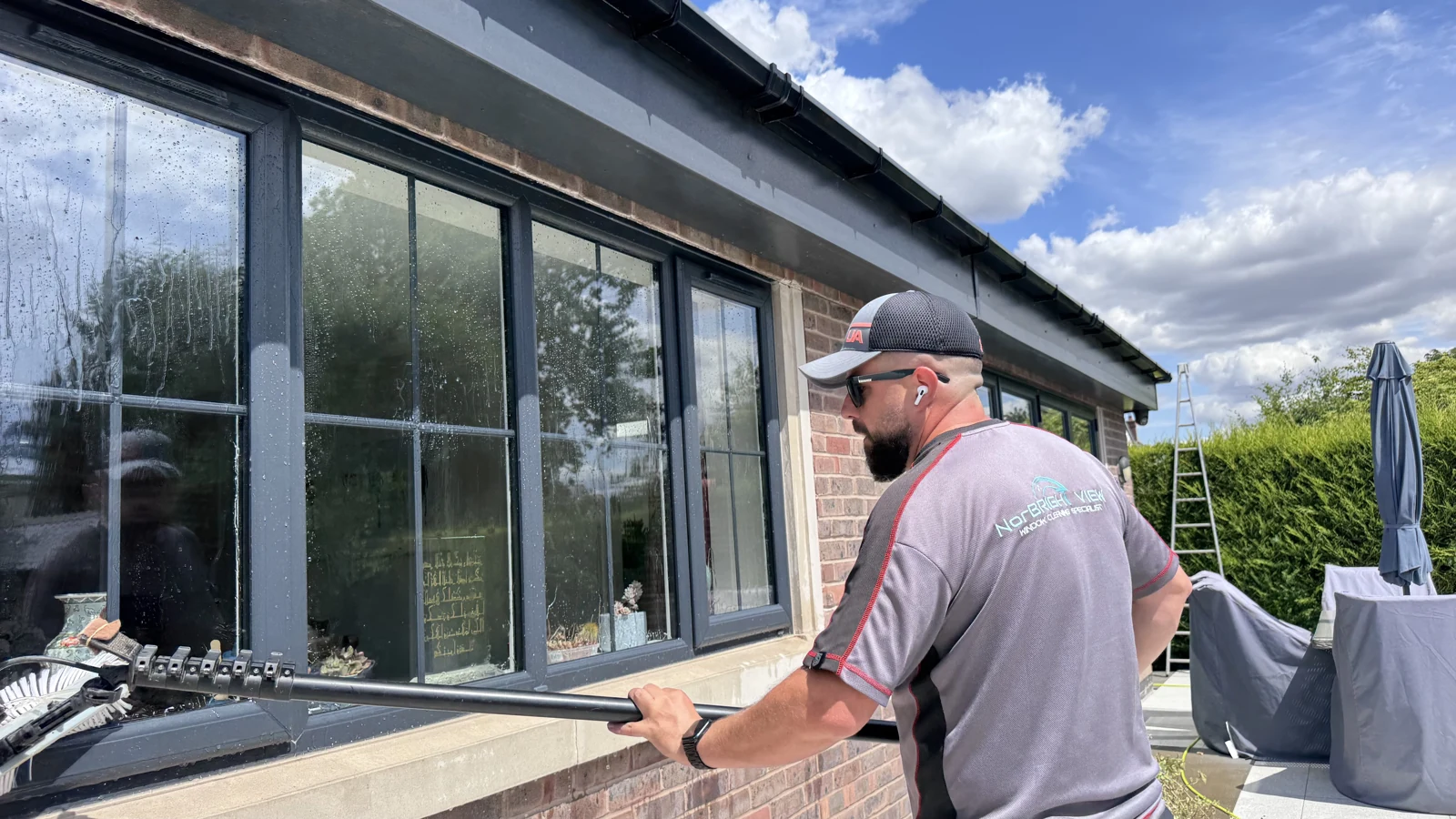 Norbi cleaning windows in his NorBRIGHT View work shirt